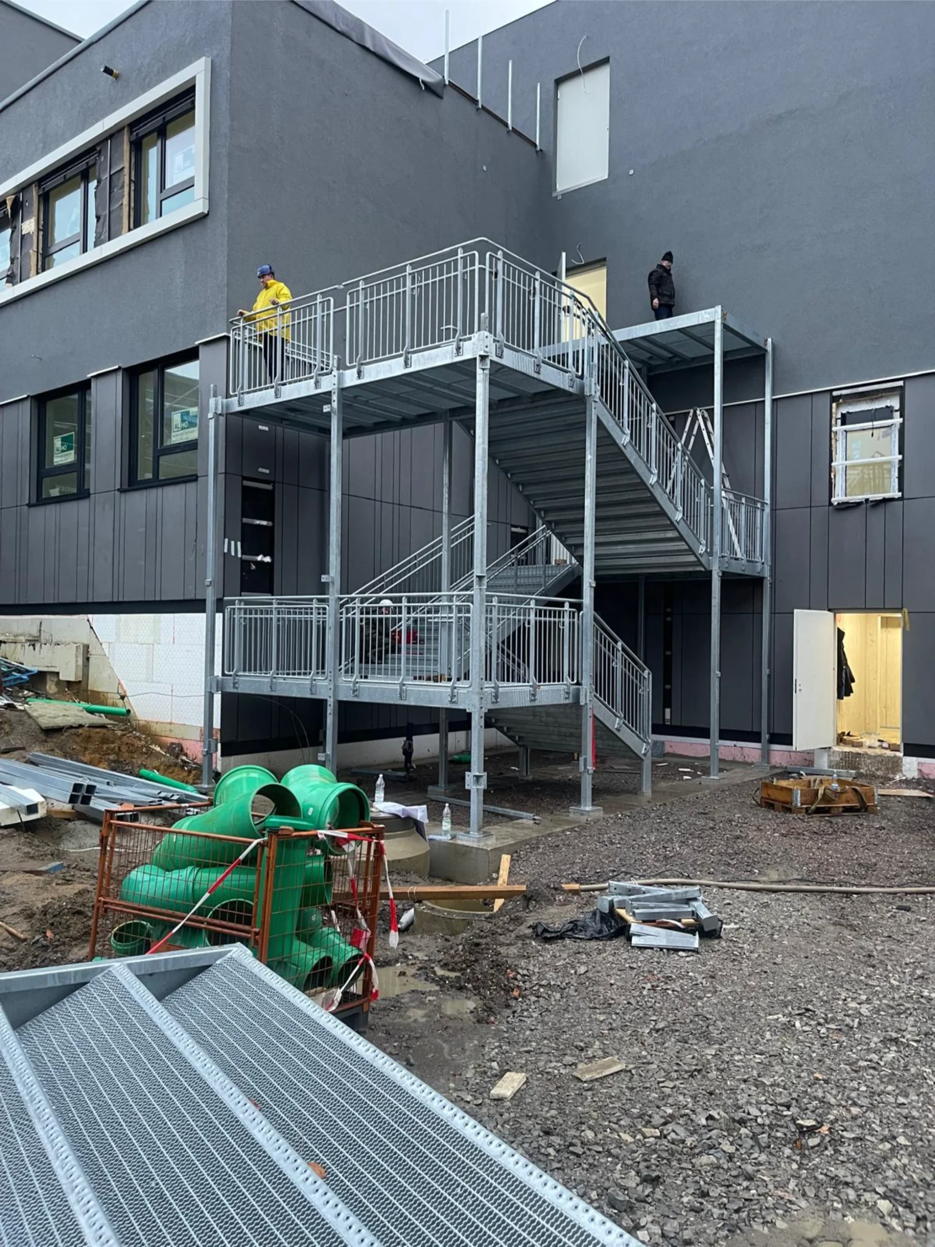 Fachgerechte Montage einer mehrstöckigen Außentreppe. Sichere und langlebige Stahlkonstruktionen am Gebäude.