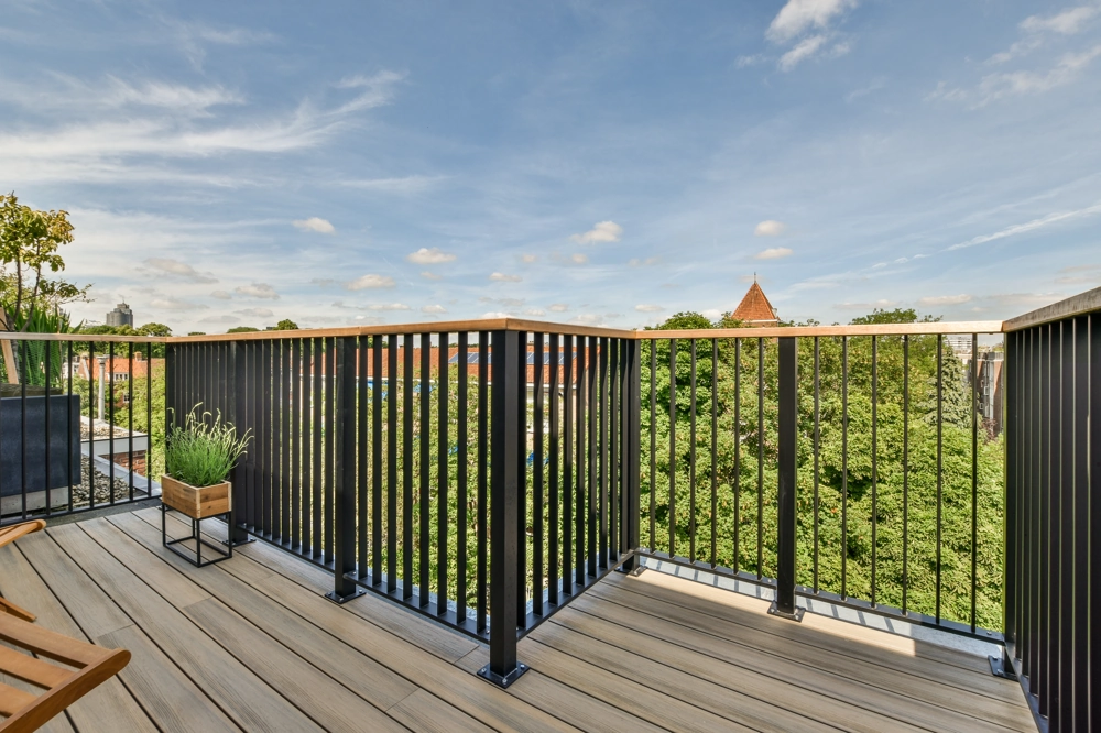 Modernes Balkongeländer aus pulverbeschichtetem Metall auf Terrasse mit Holzdekor-Belag