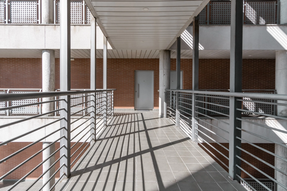 Innenbalkon mit Metallgeländer und Fliesenboden in Industriehalle