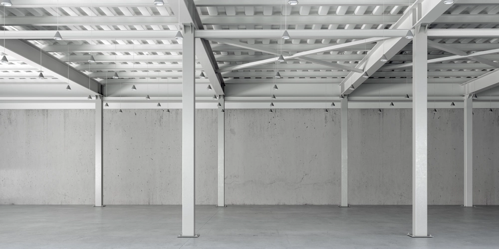 Innenansicht einer leeren Stahlkonstruktion mit Stahlstützen und Dachträgern für eine Industriehalle