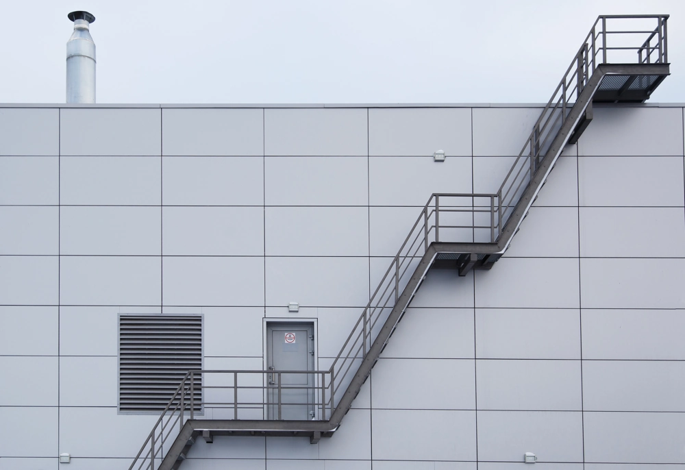 Außenansicht einer Stahlhalle mit Außentreppen und Treppengeländer aus feuerverzinktem Stahl