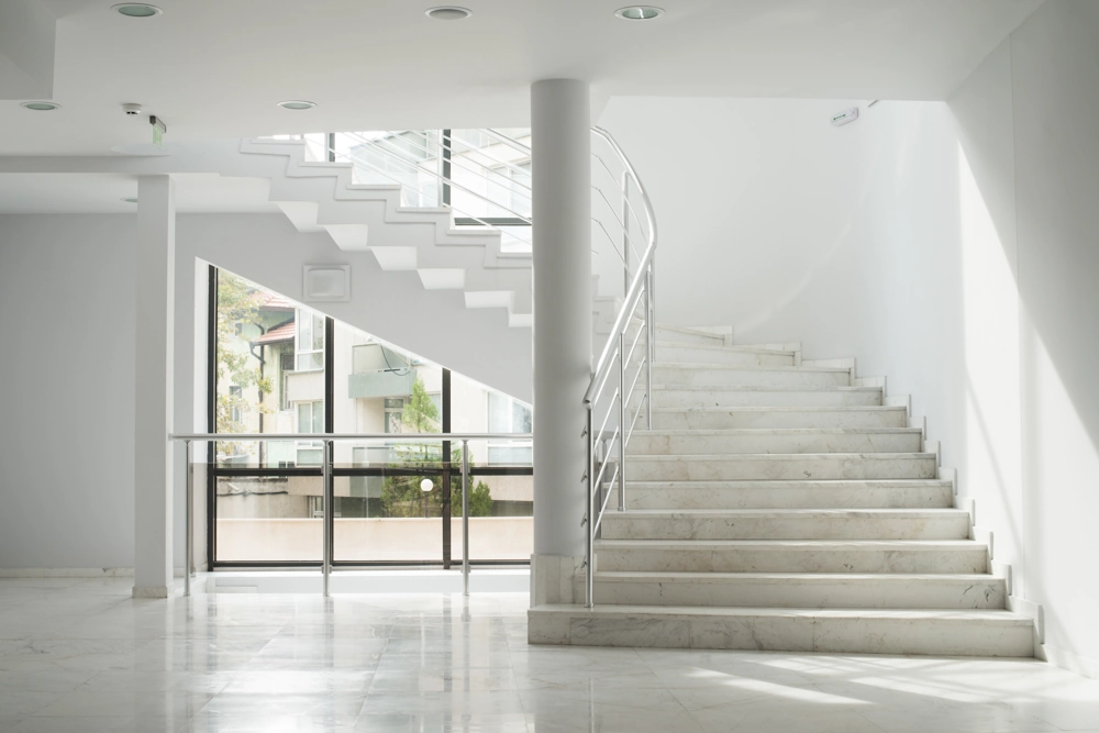 Helle Innenraum-Metalltreppe mit Marmorbelag und Edelstahlgeländer
