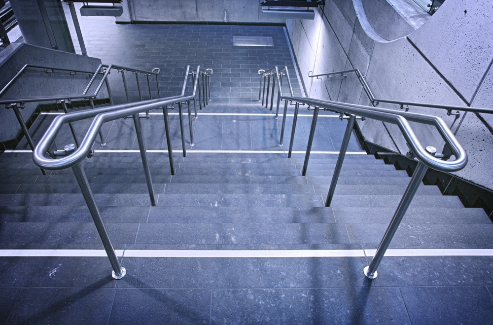 Breite Betontreppe mit beidseitigem Treppengeländer aus Edelstahl
