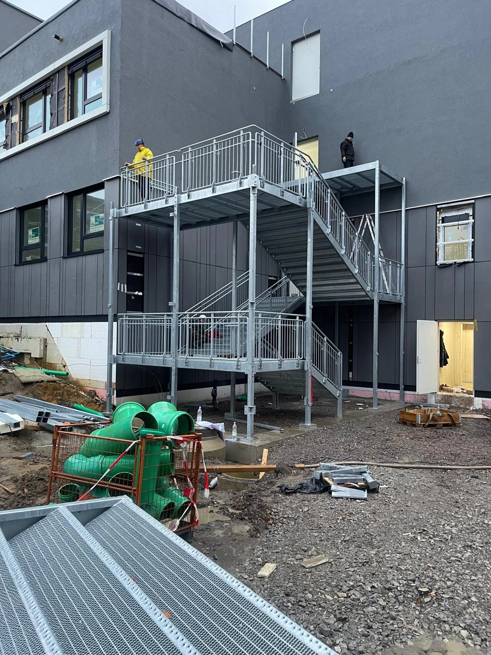 Mehrstöckige Außentreppen aus feuerverzinktem Stahl mit Geländern an Rohbau eines Bürogebäudes