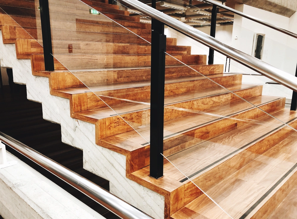 Holztreppe mit modernem Treppengeländer aus Edelstahl und Glas